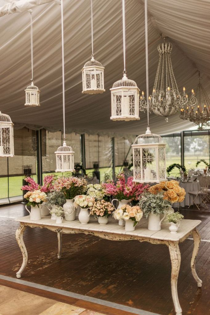 vintage wedding decor Eclectic Pitchers and Container after container of lovely blooms plus chandeliers and birdcages 682x1024