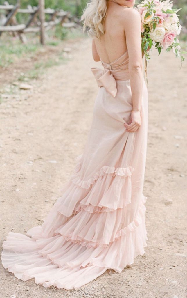 Romantic and ethereal blush wedding dress with lovely ruffled train