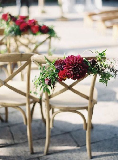 Deep red florals adorning the wedding chairs