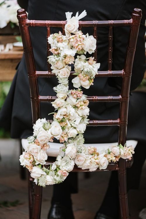 Elegant floral-adorned wedding chair with flowers