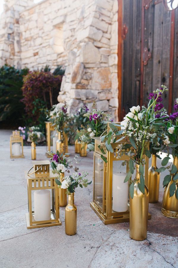 gold lanterns and spray-painted bottles wedding aisle