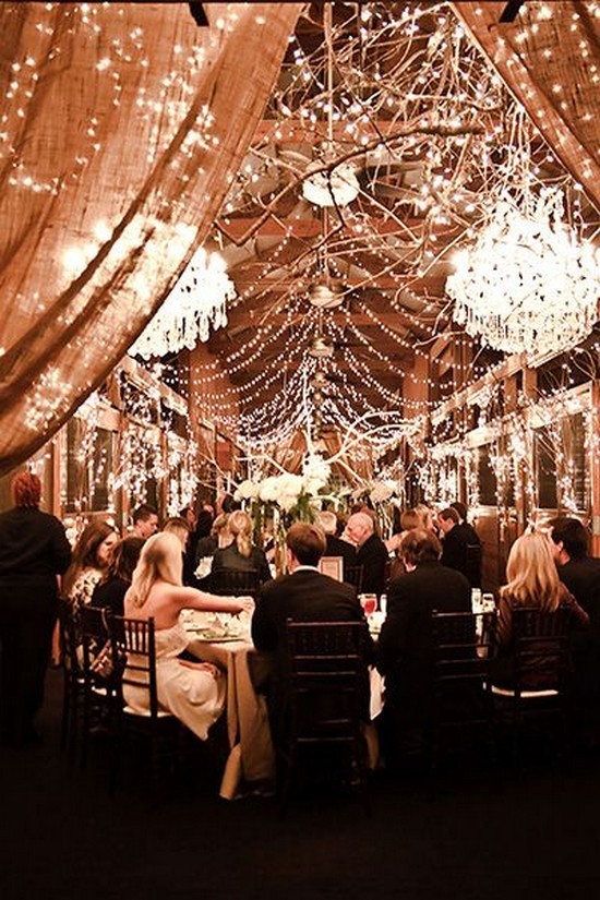 barn wedding with oversized chandeliers and strands of fairy lights