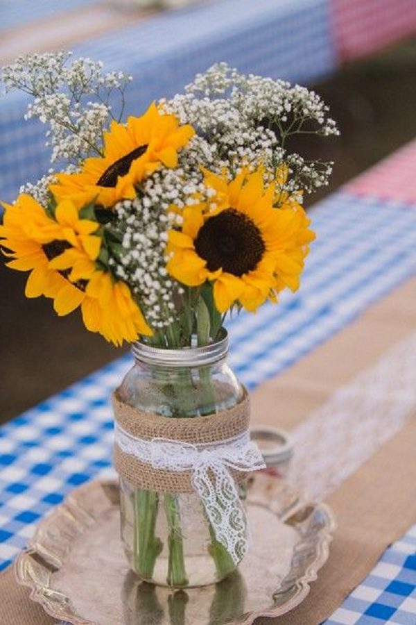 reception table setting with checkered linens, burlap runners, and mason jar centerpieces with baby’s breath and sunflowers