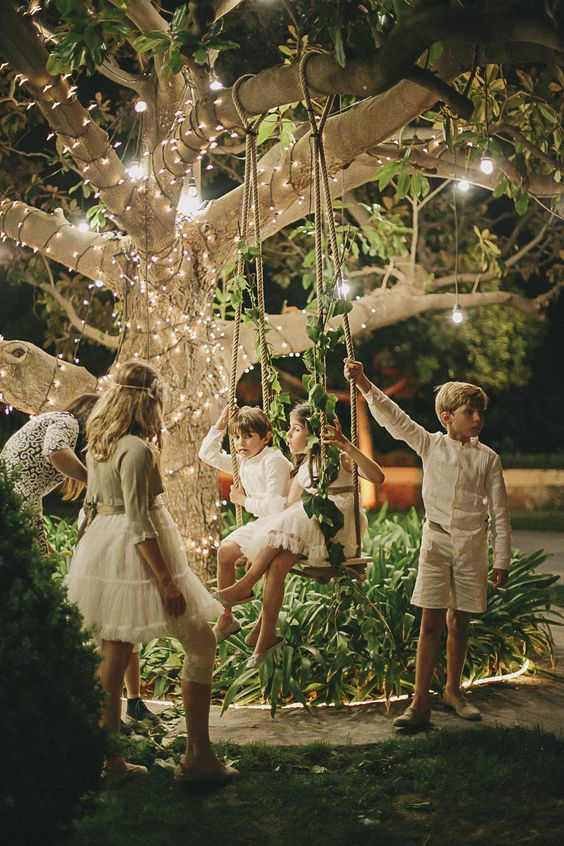Children on a Fairy light garden swing