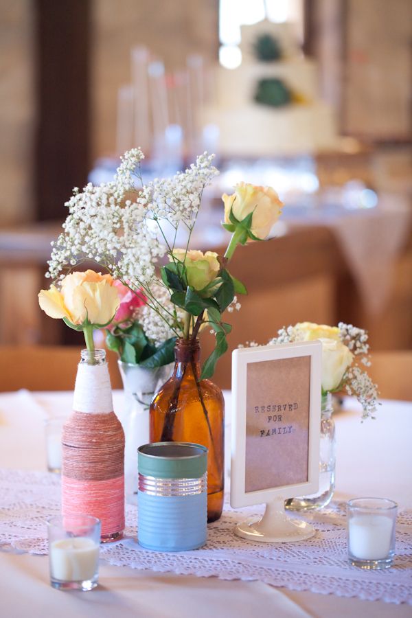 centerpiece with doily, tin can, brown glass vase and bottle wrapped in twine