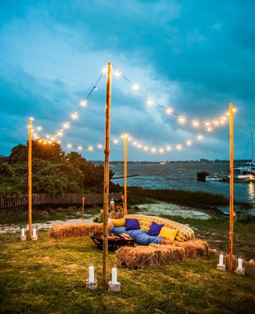 evening lakeside wedding lounge with hay bale seating and string lighting
