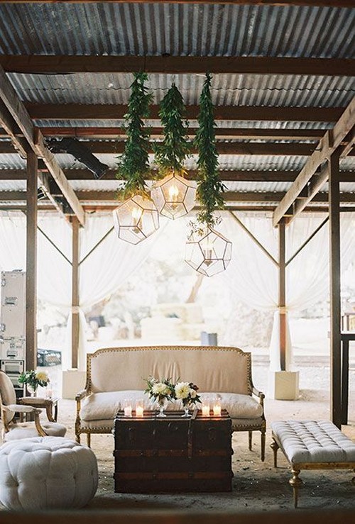 rustic-chic lounge area with couches, benches, and geometric chandeliers