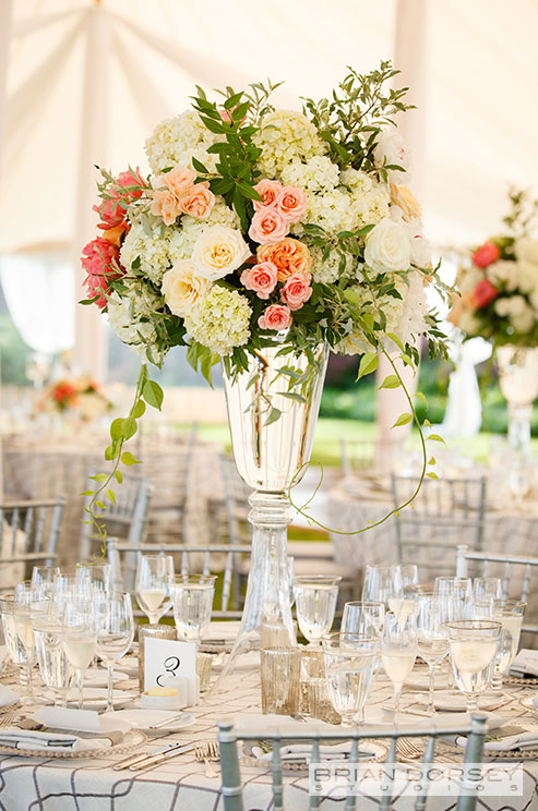 A floral wedding centerpiece of variegated roses and white hydrangeas