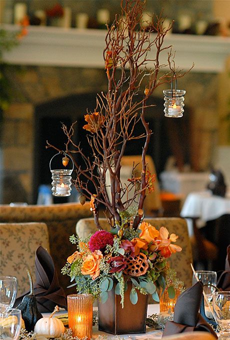 Arrangement of roses celosia cymbidium and vanda orchids lotus pods eucalyptus and Manzanita branches