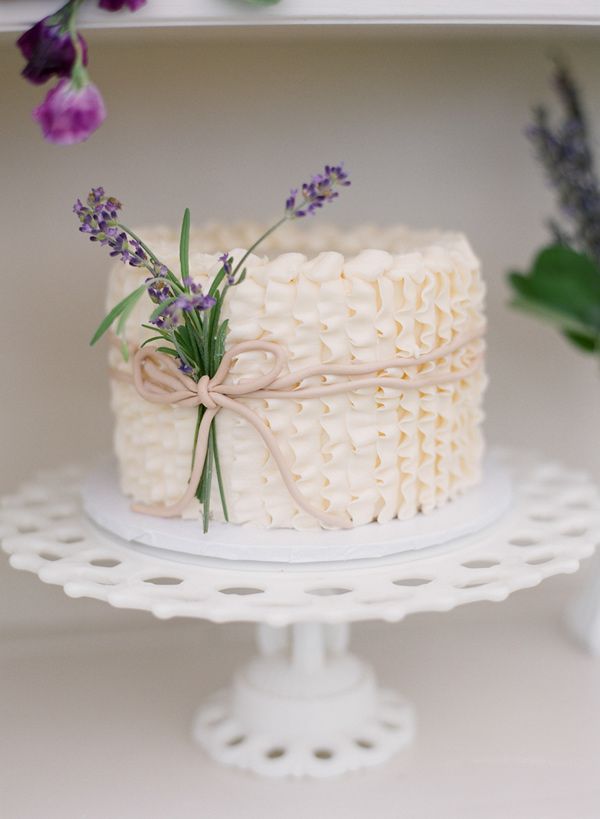 Cream ruffled wedding cake with lavender details