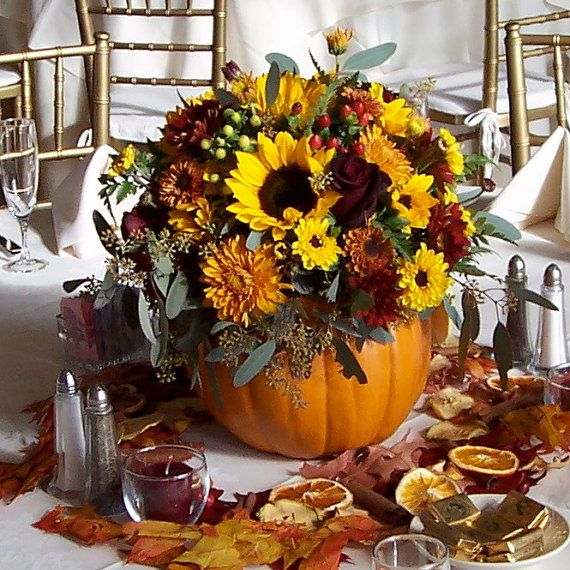 Fall wedding centerpiece made of silk flowers in faux pumpkin