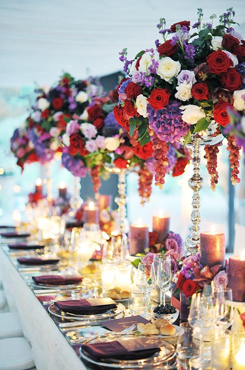 Opulent wedding centerpieces of red, white and purple roses, purple