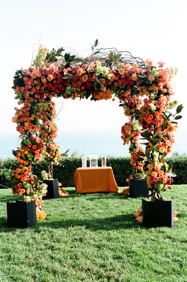 Orange and coral wedding ceremony alter decor