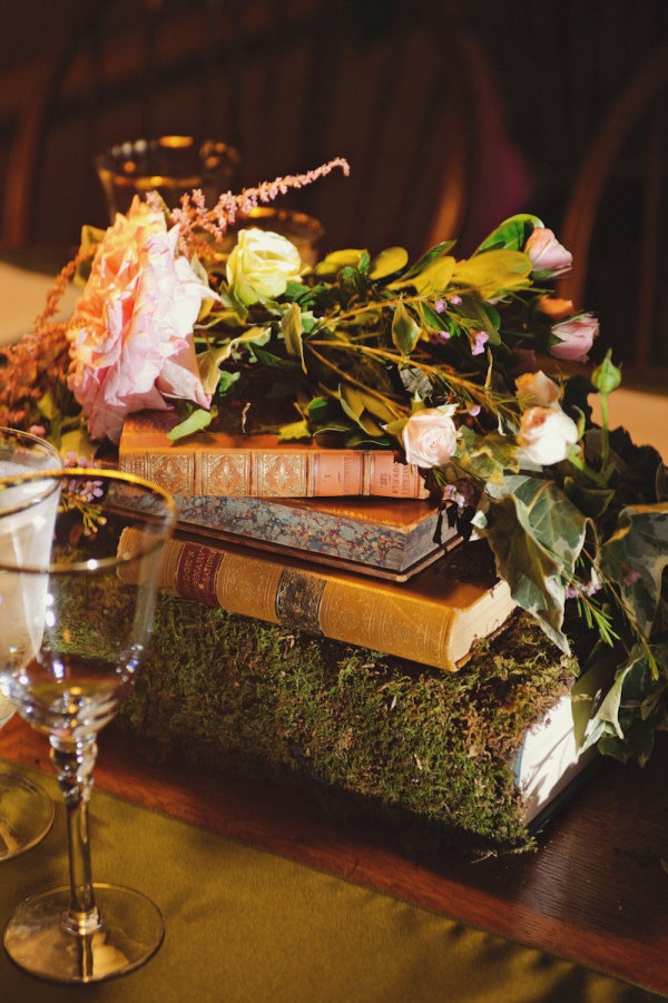 Pretty moss-covered books as centerpieces