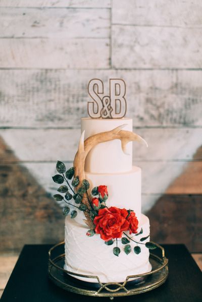 Rustic white and red wedding cake with antler