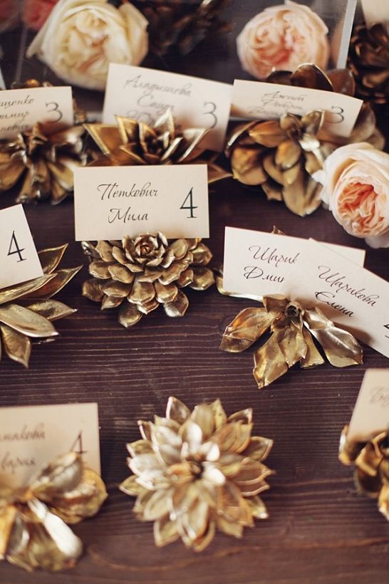 Succulent escort card holders that are spray painted gold