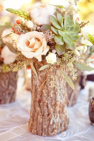 Tree stump vases filled with flowers for fall wedding centerpiece