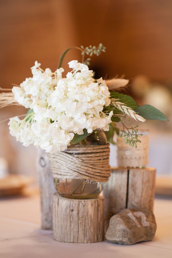 White hydrangeas were placed in jars wrapped with sisal twine