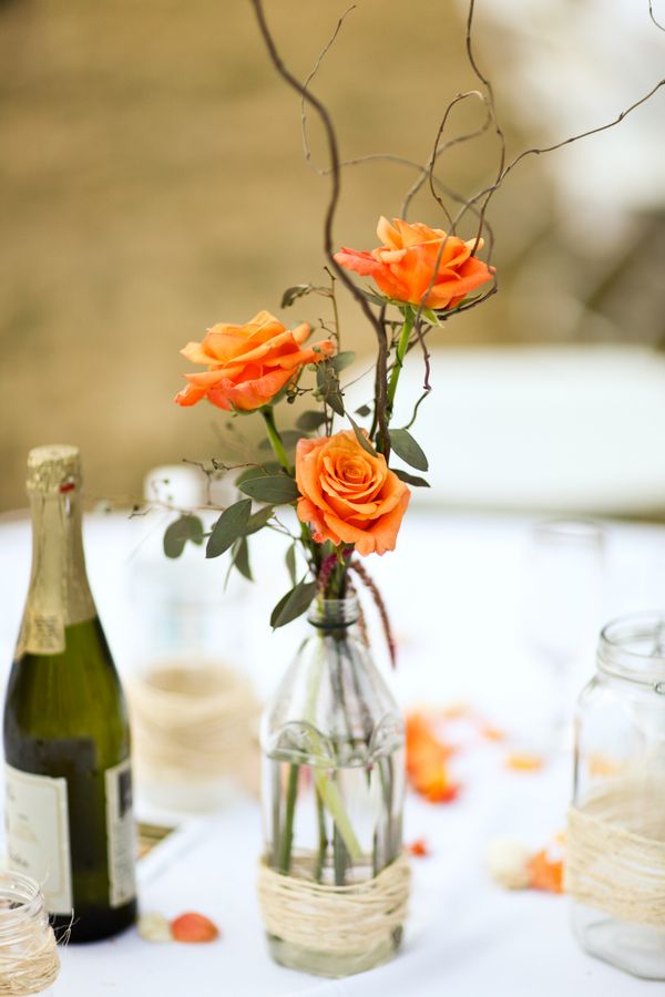fall wedding centerpiece with orange roses tiny branches and leaves