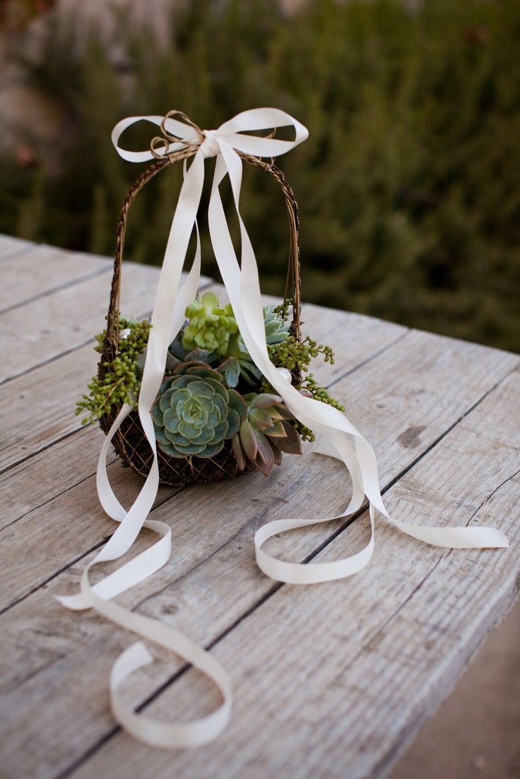 flower girl basket covered in moss with scattered purple and green succulents