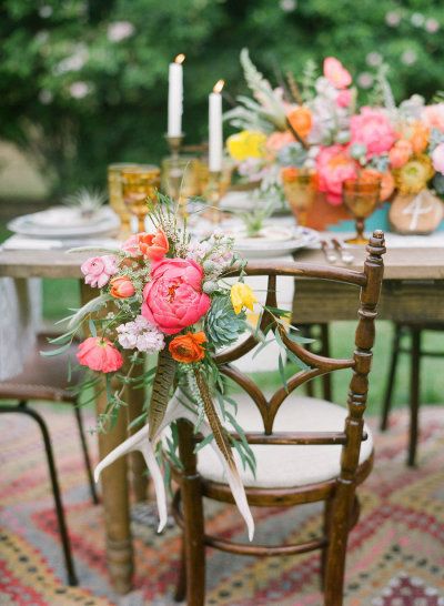 peonies ranunculus deer antler and feathers decorating the seats