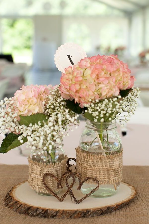 reception centerpieces featured burlap-covered mason jars filled with hydrangeas and baby's breath