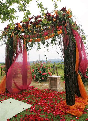 red and orange flower wedding arch for rustic weddings