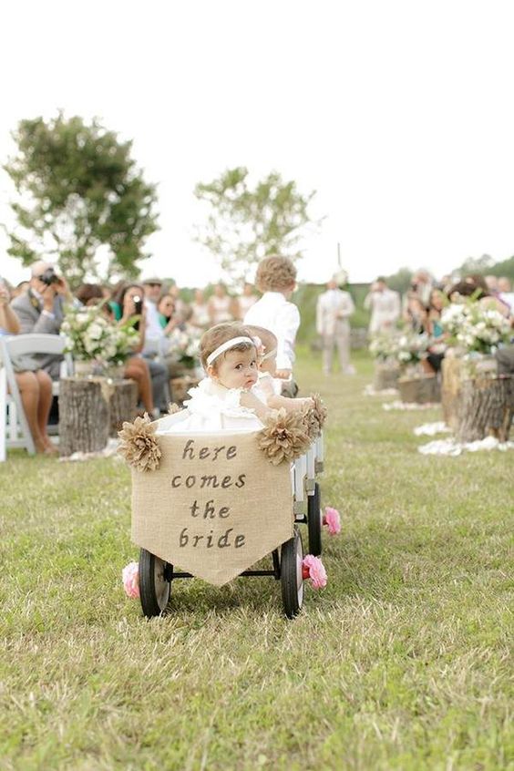 ring bearer pulls young flower girls in wagon