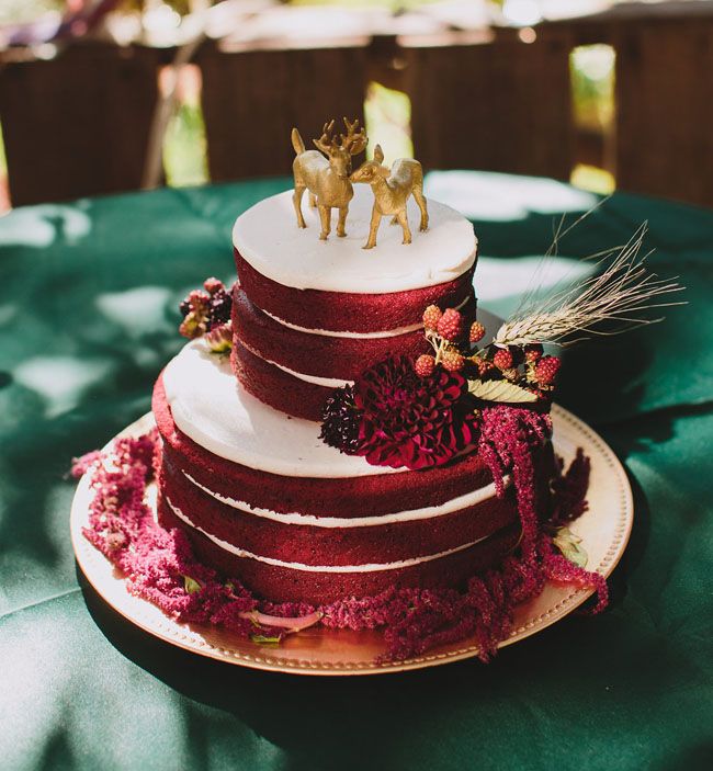 rustic deep red naked wedding cake with gold deers cake toppers