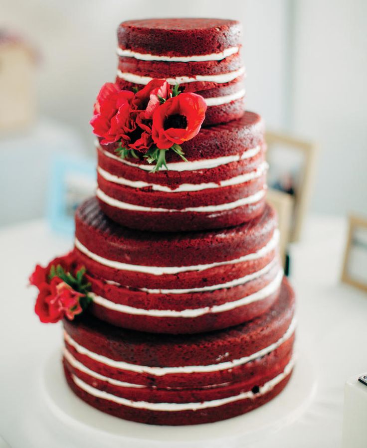 simple deep red naked wedding cake with clusters of red anemones