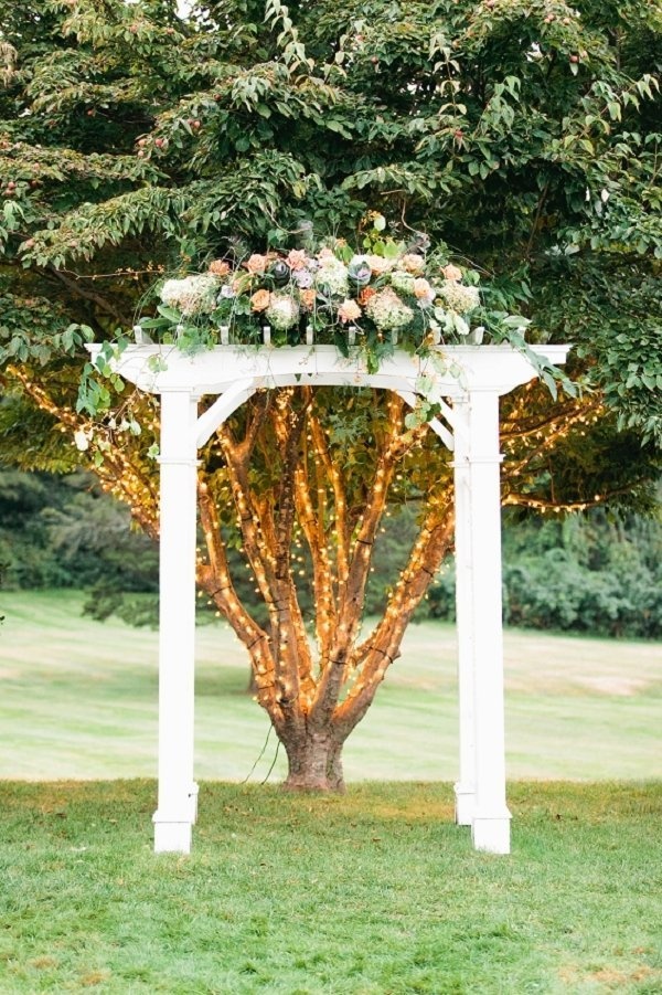 white wedding arch with flower and lights
