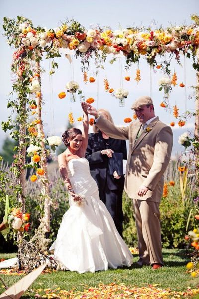 white yellow and orange flowers wedding arch for rustic fall weddings