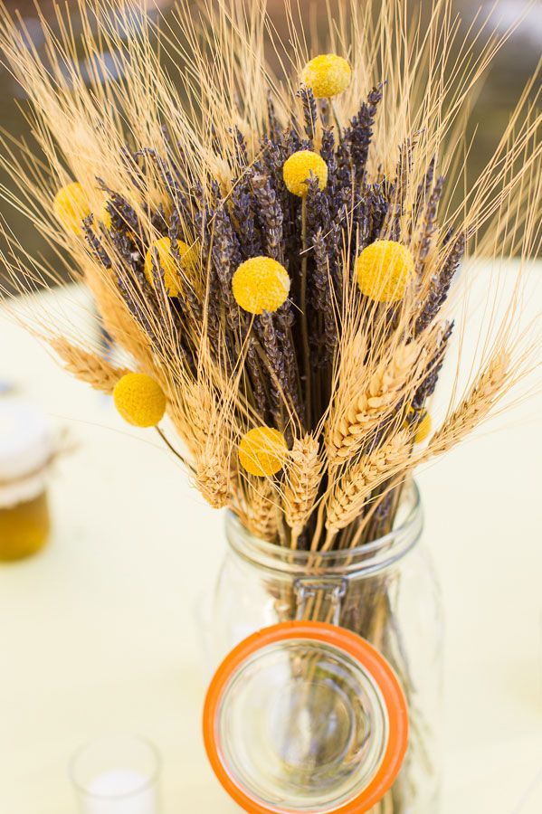 A dried floral arrangement featuring wheat lavender and yellow billy balls