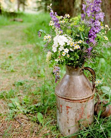 An old jug with wildflowers enhances the natural beauty of the clearing in the woods