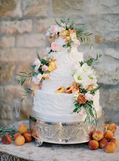 Decadent buttercream wedding cake with flowers and peach
