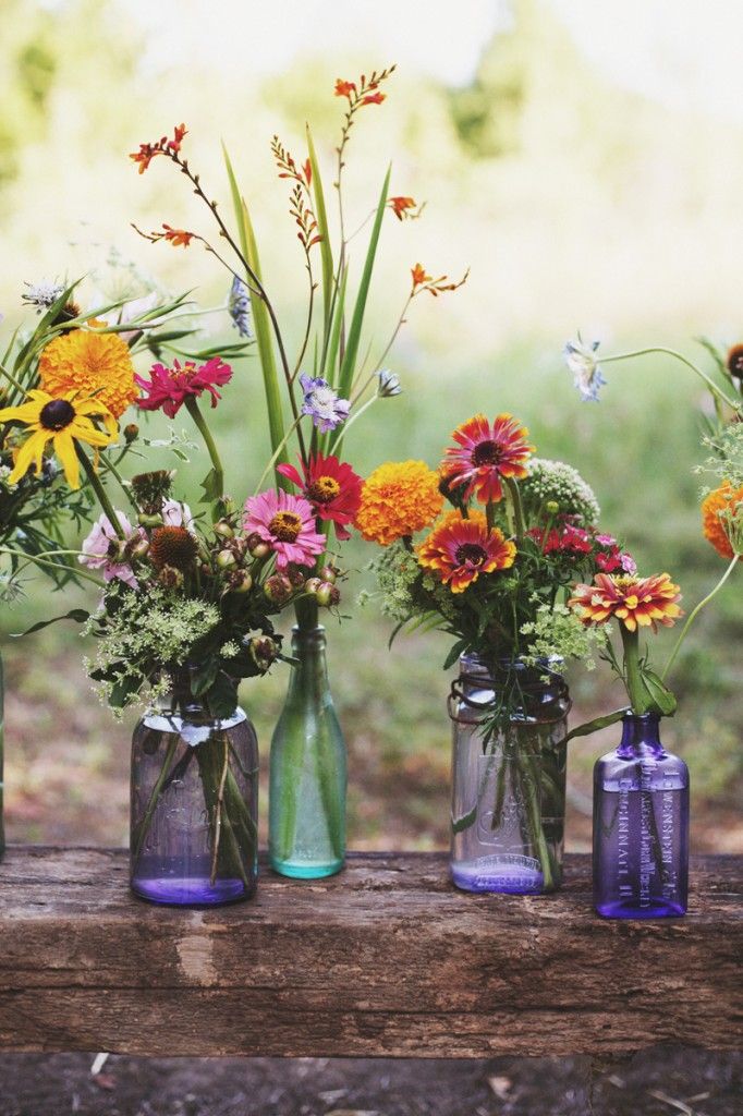 Vibrant wildflowers in light blue vases wedding decor