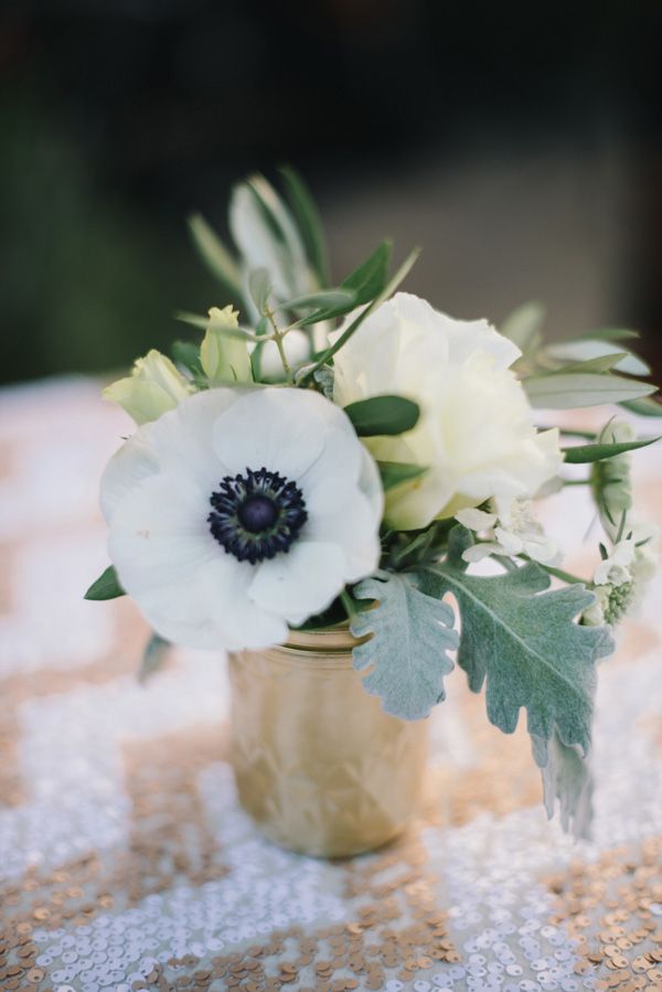 anemones in gold mason jar on a sequin chevron tablecloth