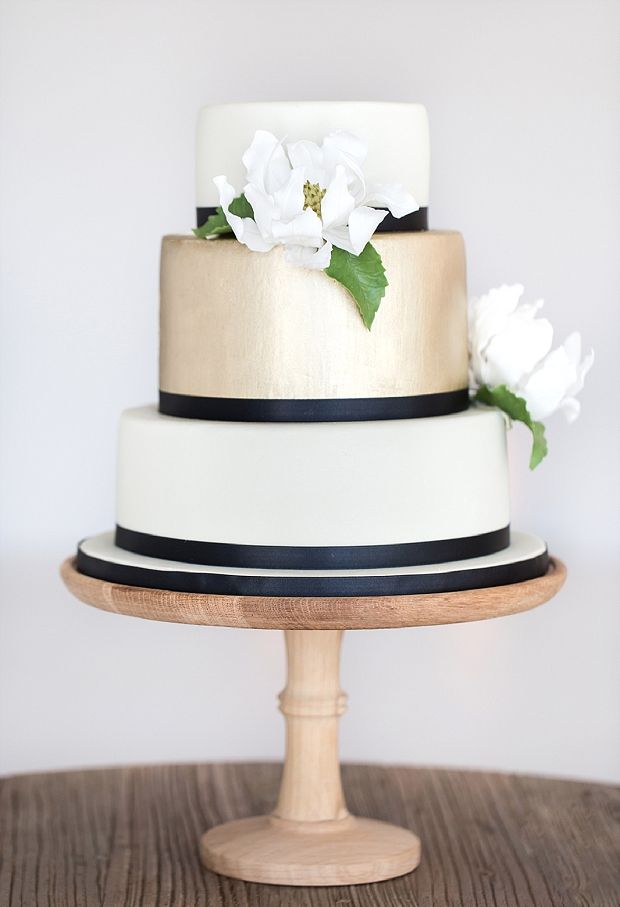 black and white wedding cake with brushed gold gum-paste magnolia and navy ribbon