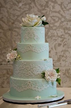 blue and white wedding cake with lace and flower details