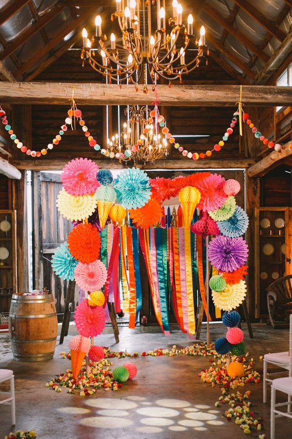 colorful wedding ceremony backdrop with paper decor and ribbons