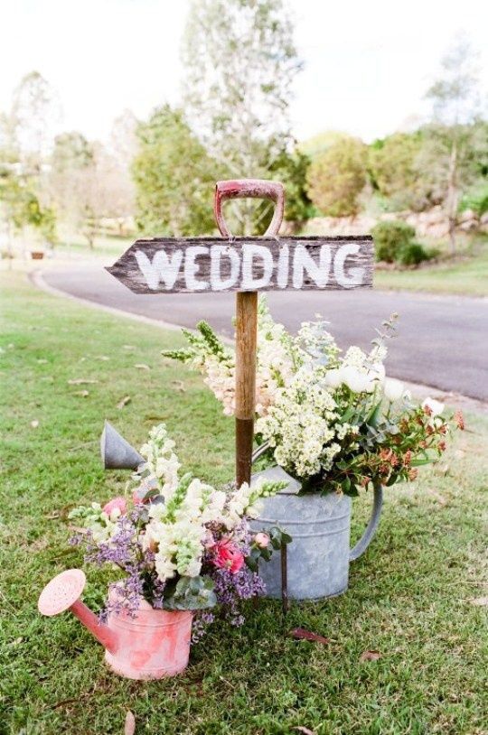 flowers in a watering can wedding ceremony entrance