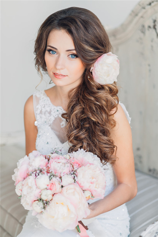 long half up wavy wedding hairstyle with pink flower