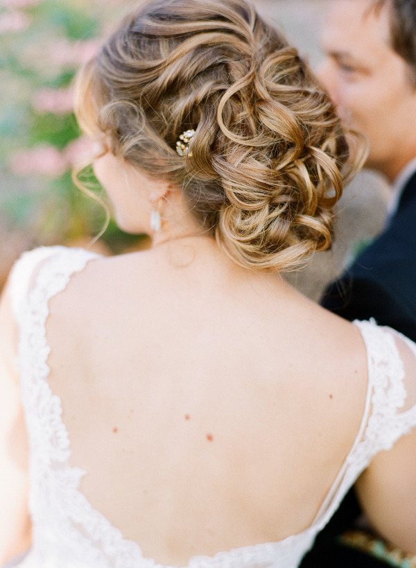 romantic messy loose curls wedding updo with beaded pin