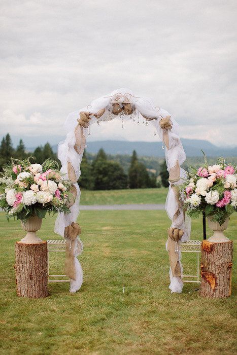 rustic tree stump and flowers wedding arch