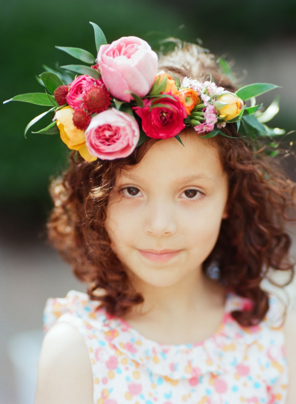 short curly flower girl hairstyle with flowers crown