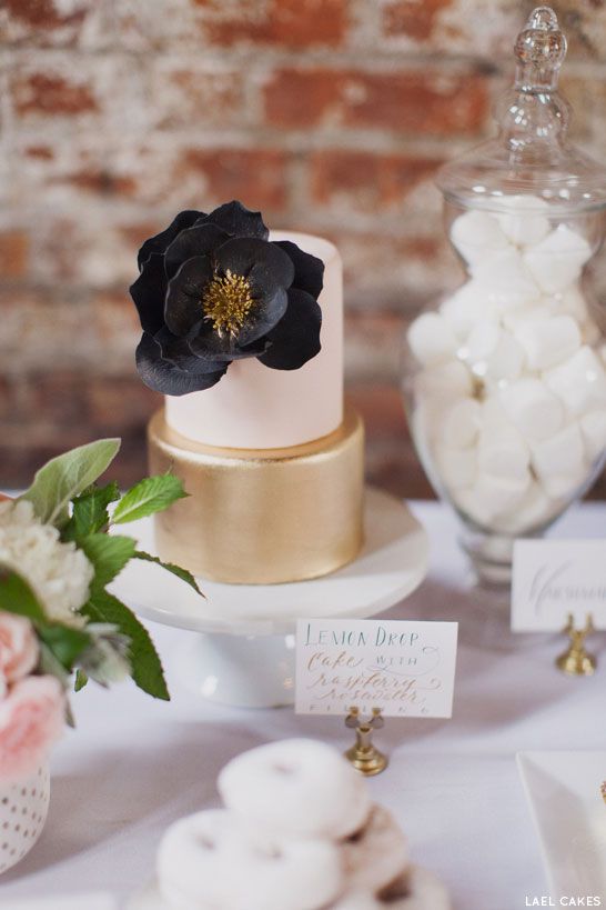 simple white and gold wedding cake with black flower