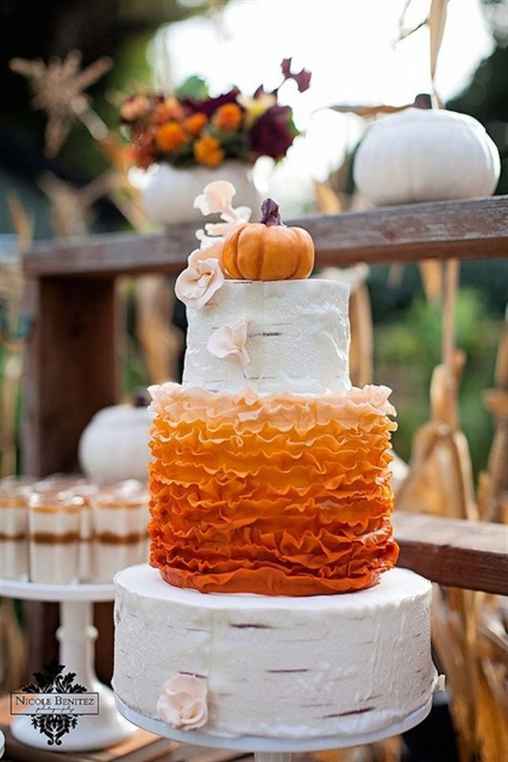 tired cake with an orange ombre ruffle mid tier and a pumpkin topper