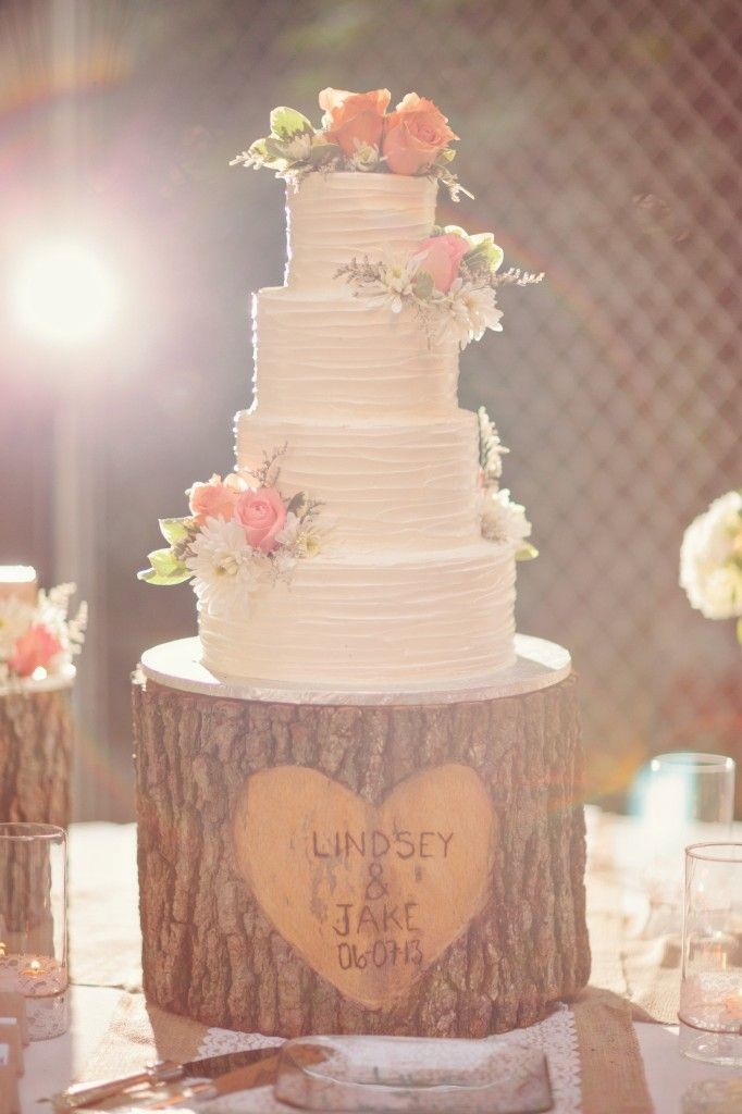 tree stump cake stand is adorable with clusters of fresh flowers on the cake
