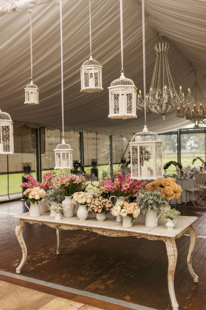 vintage wedding decor-Eclectic Pitchers and Container after container of lovely blooms plus chandeliers and birdcages