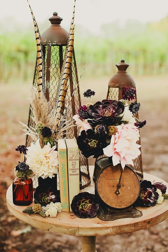 wedding centerpiece with vintage books an antique clock stunning peonies and succulents